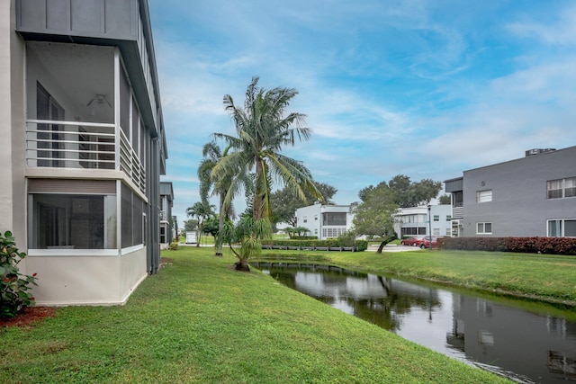 view of green lawn with a water view