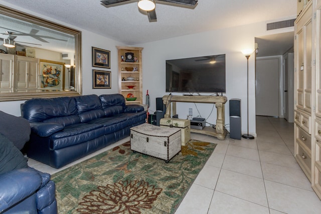 living room featuring a textured ceiling, light tile patterned flooring, and ceiling fan