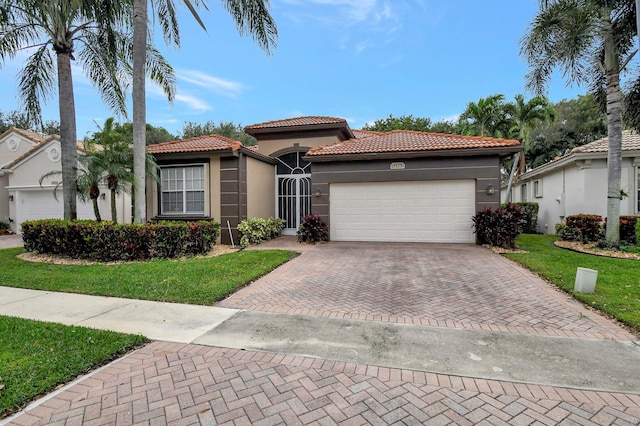 mediterranean / spanish-style home featuring a garage and a front yard