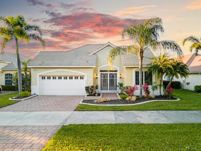 view of front of home featuring a garage and a lawn