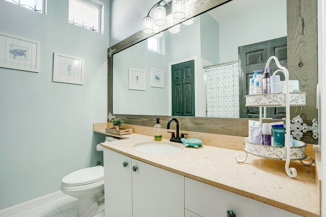 bathroom with vanity, walk in shower, tile patterned flooring, and toilet