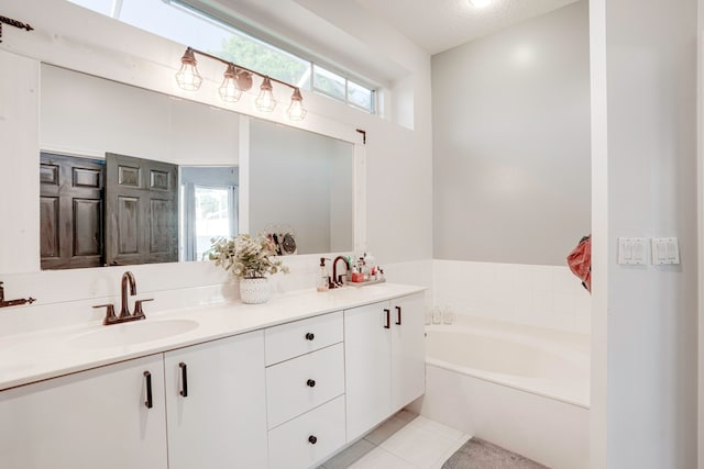 bathroom with tile patterned flooring, vanity, a textured ceiling, and a washtub