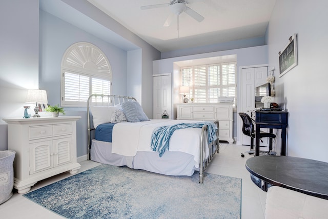 tiled bedroom featuring multiple windows and ceiling fan