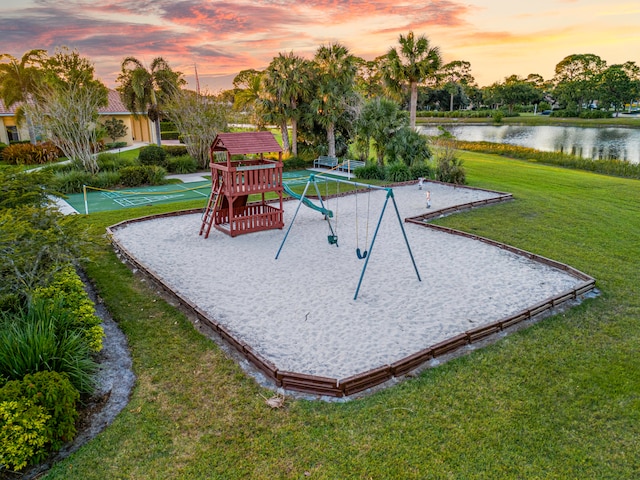 view of property's community featuring a lawn, a playground, and a water view