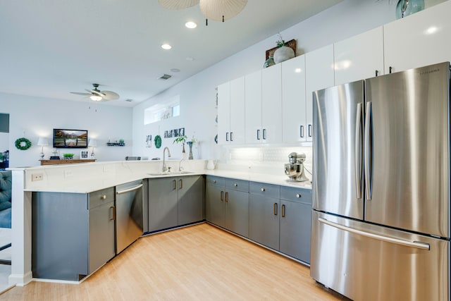 kitchen with white cabinetry, light hardwood / wood-style floors, stainless steel appliances, and sink