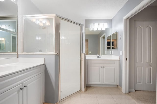 bathroom with tile patterned flooring, vanity, a textured ceiling, and a shower with shower door