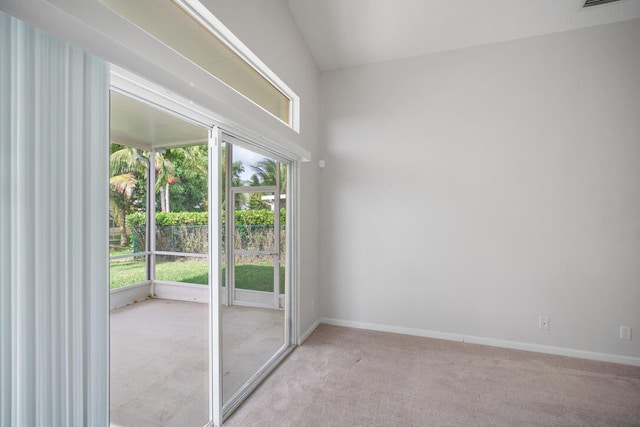 unfurnished room with light colored carpet and vaulted ceiling