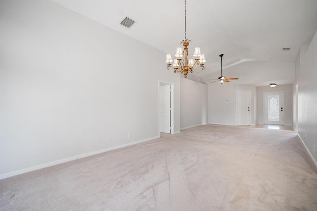 carpeted spare room with ceiling fan with notable chandelier and vaulted ceiling