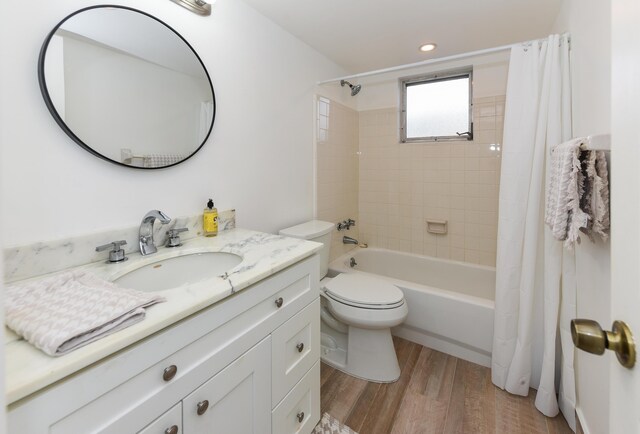 full bathroom with wood finished floors, shower / bath combination with curtain, vanity, toilet, and recessed lighting