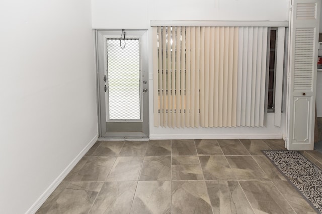 doorway to outside featuring baseboards