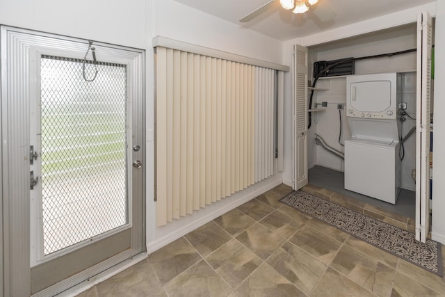 bathroom featuring stacked washer / dryer and a ceiling fan