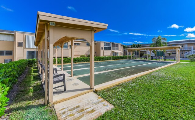 view of property's community with shuffleboard, a lawn, and a residential view