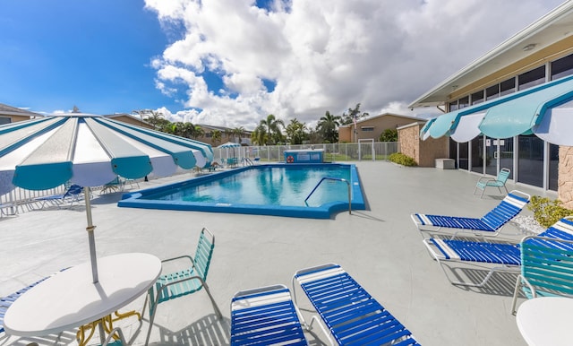 community pool featuring fence and a patio