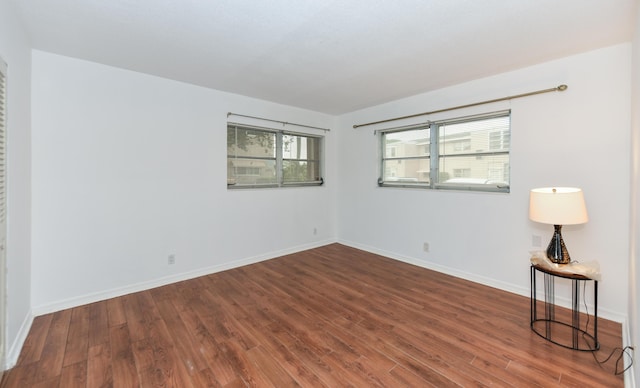 spare room with wood finished floors and baseboards