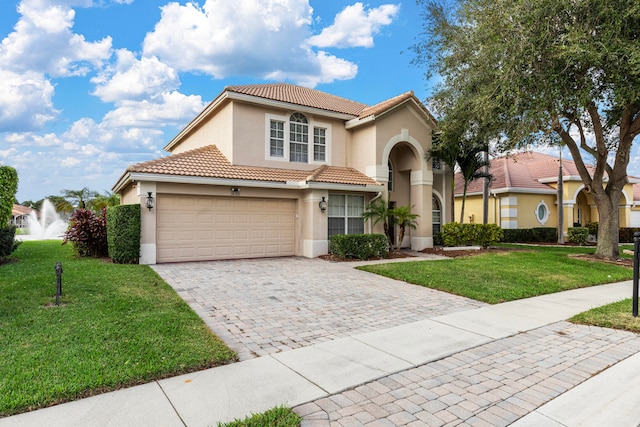 mediterranean / spanish-style house featuring a garage and a front lawn