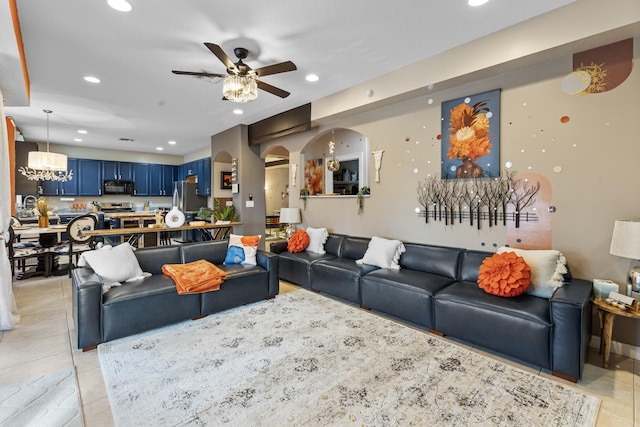 living room featuring ceiling fan with notable chandelier and light tile patterned floors