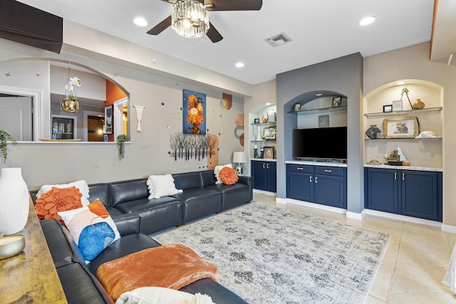 tiled living room with built in shelves and ceiling fan