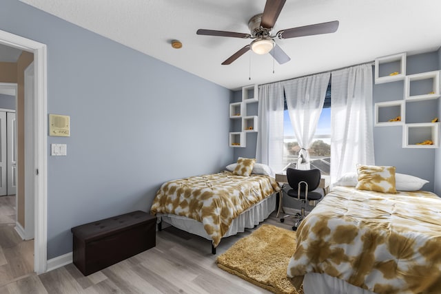 bedroom with ceiling fan, a textured ceiling, and light hardwood / wood-style flooring