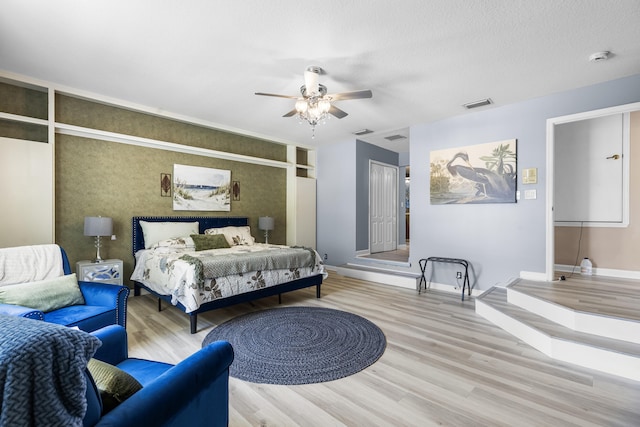 bedroom featuring ceiling fan, a textured ceiling, and light wood-type flooring