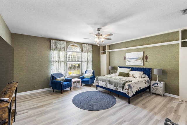 bedroom with a textured ceiling, ceiling fan, and light hardwood / wood-style flooring