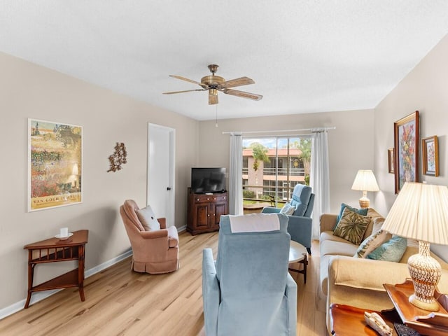 living room with ceiling fan and light hardwood / wood-style flooring