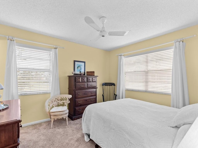 bedroom featuring a textured ceiling, light carpet, and ceiling fan