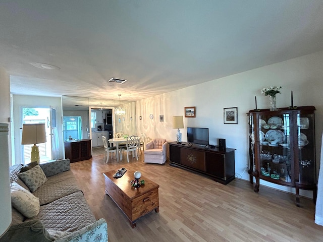 living room featuring an inviting chandelier and hardwood / wood-style flooring