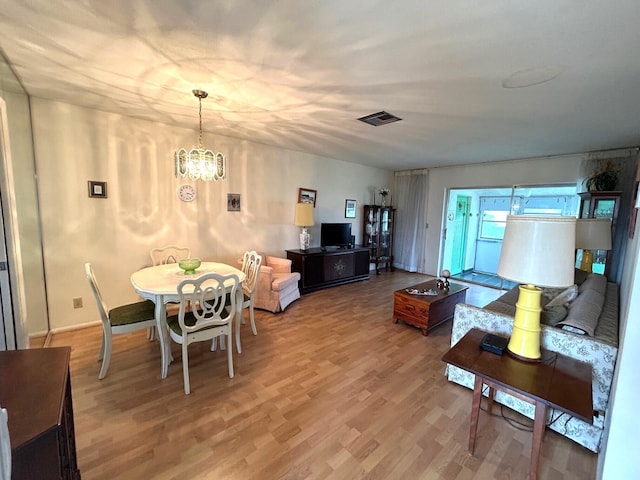 living room featuring wood-type flooring and a notable chandelier