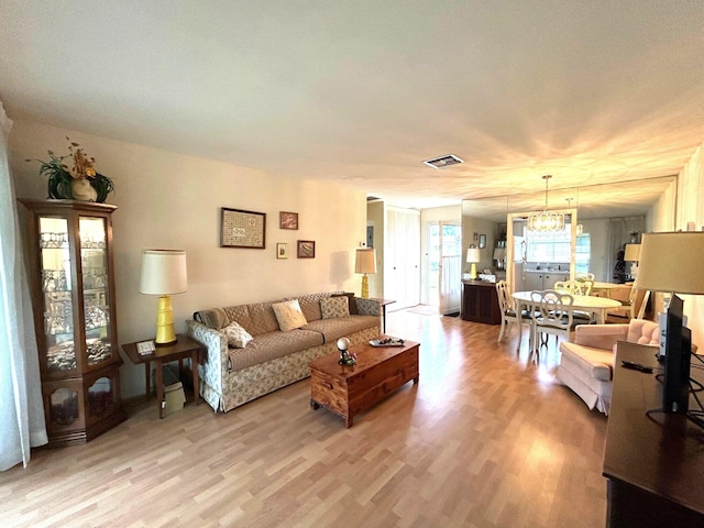 living room with hardwood / wood-style floors and a chandelier