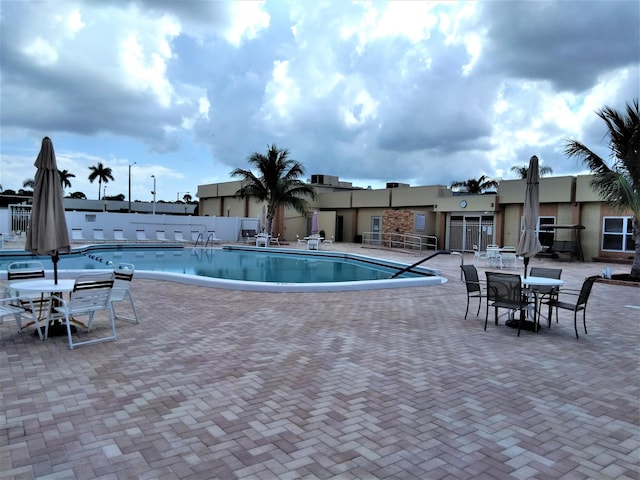 community pool featuring fence and a patio