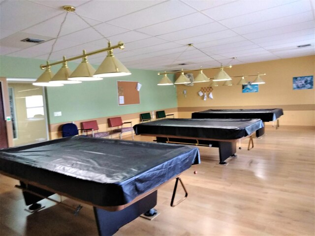 recreation room featuring billiards table, a paneled ceiling, and wood finished floors