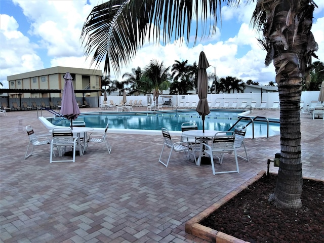 community pool with fence and a patio area