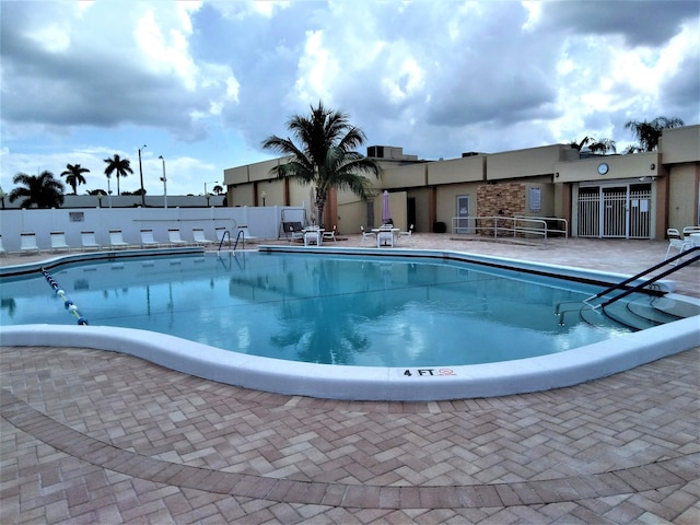 community pool featuring fence and a patio