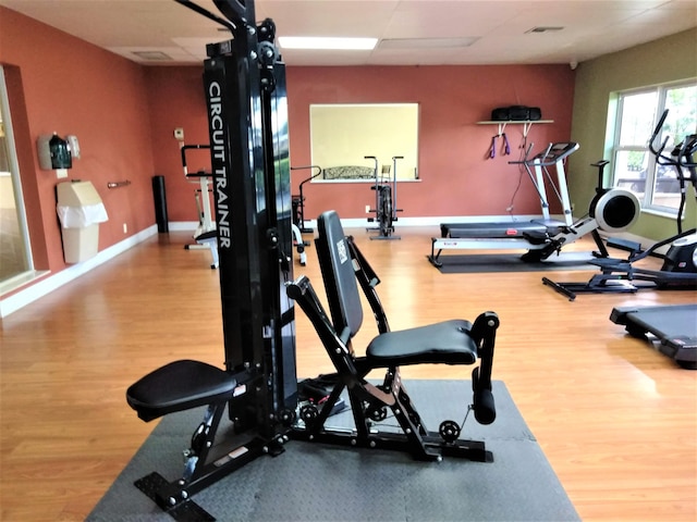 exercise room with wood finished floors and baseboards
