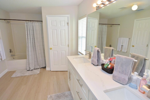 bathroom with wood-type flooring, vanity, a textured ceiling, and shower / tub combo with curtain