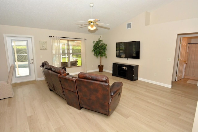 living room featuring a textured ceiling, light wood-type flooring, lofted ceiling, and ceiling fan