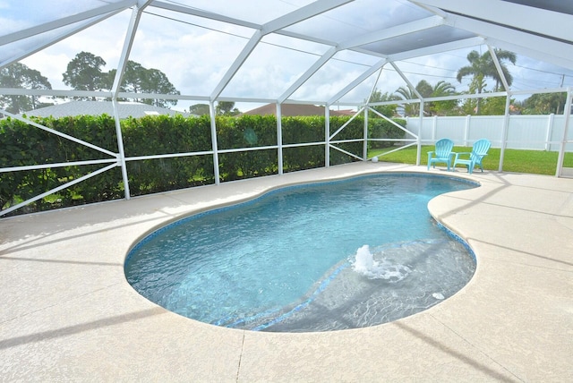 view of pool with glass enclosure and a patio area