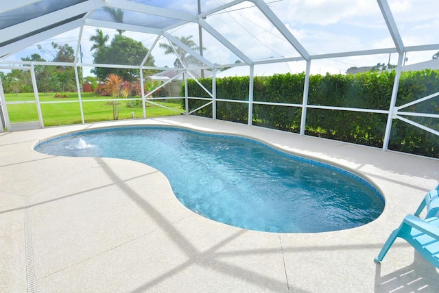 view of swimming pool with a lanai, pool water feature, a patio, and a yard