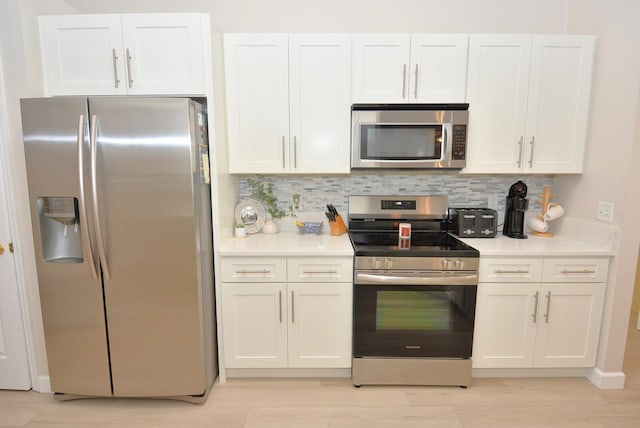 kitchen featuring white cabinetry, appliances with stainless steel finishes, and backsplash