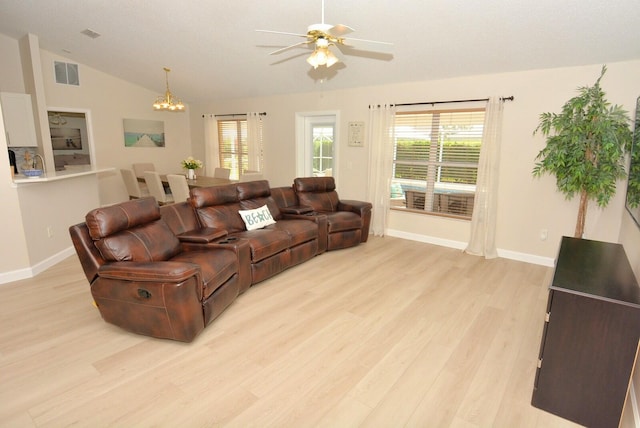 living room with ceiling fan with notable chandelier, light hardwood / wood-style flooring, and lofted ceiling