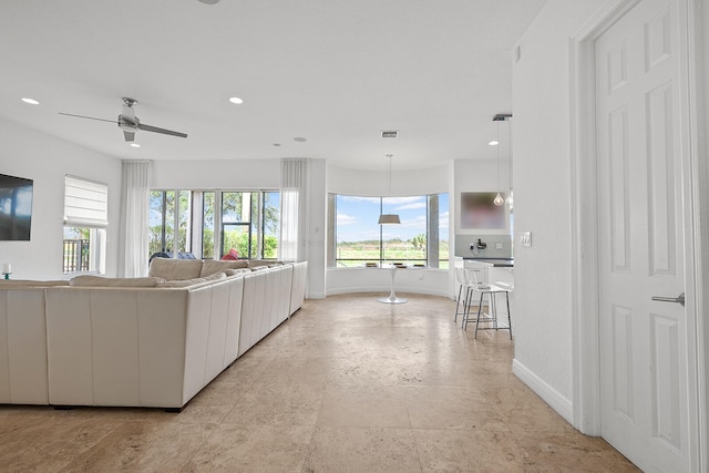 unfurnished living room featuring ceiling fan