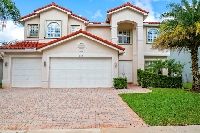 mediterranean / spanish home with a front yard and a garage