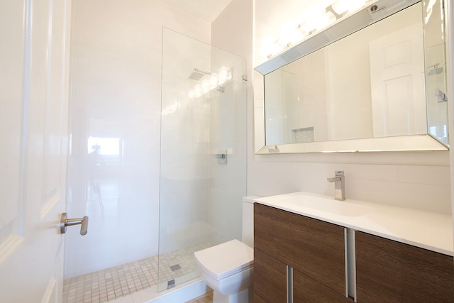 bathroom featuring vanity, toilet, and a shower with door