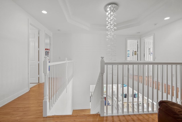 corridor featuring light hardwood / wood-style floors and an inviting chandelier