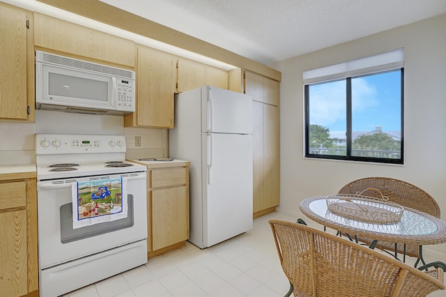 kitchen with light brown cabinetry, backsplash, and white appliances