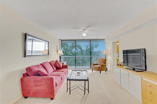 carpeted living room with expansive windows, ceiling fan, and a textured ceiling