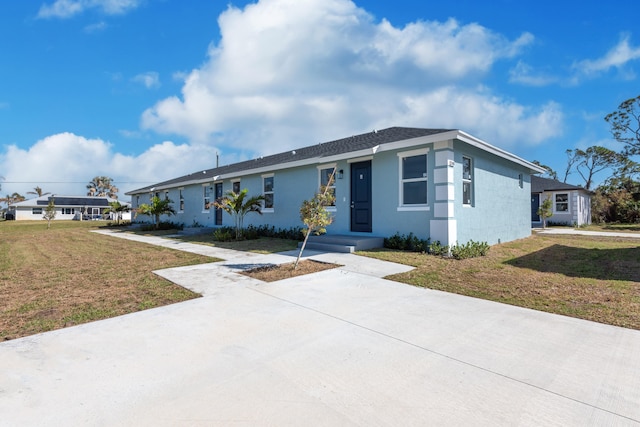 ranch-style house featuring stucco siding and a front lawn