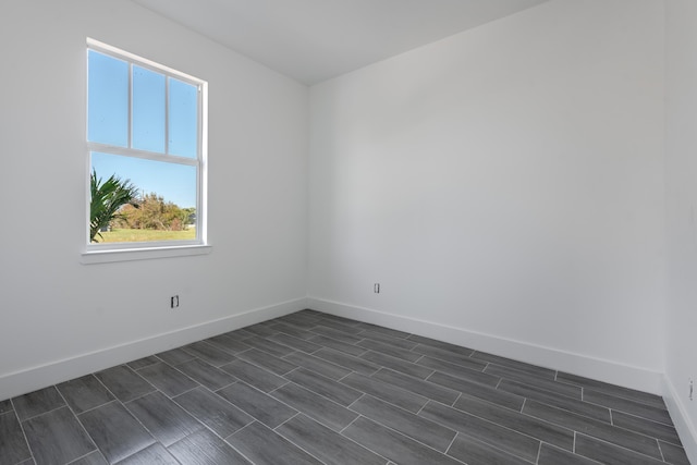 unfurnished room with wood finish floors and baseboards