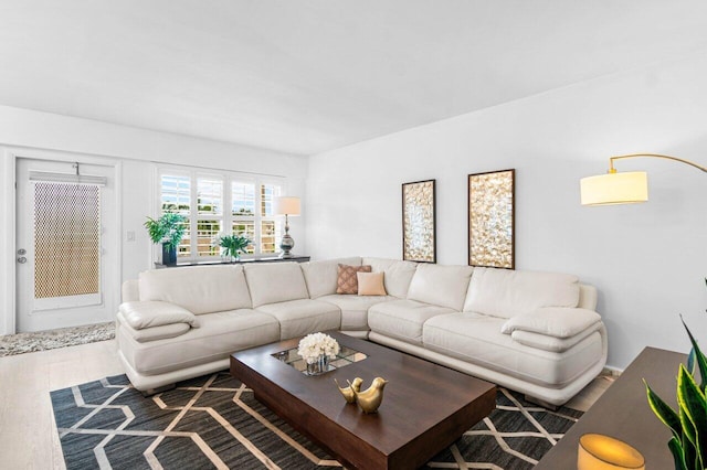 living room featuring light hardwood / wood-style floors, a notable chandelier, and sink