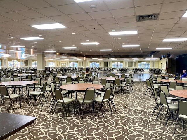 carpeted dining room with a drop ceiling